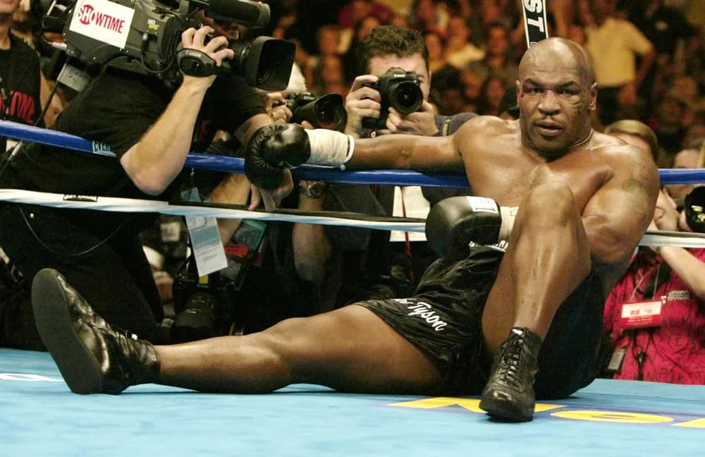 Mike Tyson sits on the canvas after being knocked out by Danny Williams.